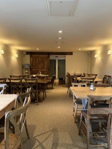 a dining room with wooden tables and wooden chairs at White Hart Ufford in Ufford