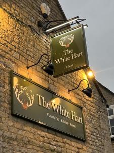 una señal para el sombrero blanco en el lateral de un edificio en White Hart Ufford- Stamford en Ufford