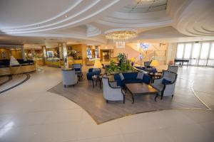 una hall con tavoli e sedie in un edificio di Le Passage Cairo Hotel & Casino a Il Cairo