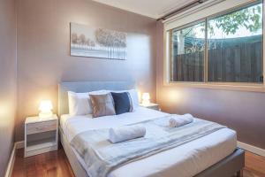 1 dormitorio con 1 cama grande y ventana en Nunawading Beautiful 3br Housedeckingcourtyard, en Nunawading