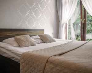 1 dormitorio con 1 cama con sábanas blancas y ventana en Hotel Korona, en Rybnik