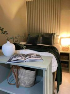a bedroom with a bed and a table with a book at Stylish studio suite in the heart of Brighton in Brighton & Hove