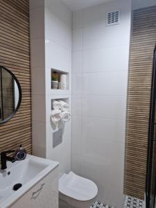 Baño blanco con aseo y lavamanos en Apartament Staromiejski Rapackiego 45 en Grudziądz
