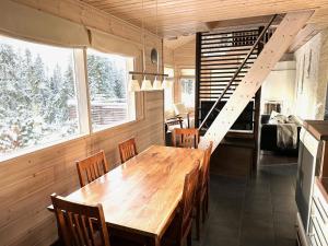 a dining room with a wooden table and chairs at Hietavilla Borealis - Hot tube - Sauna - AC - Fireplace - 11kW EV-refuel - Landscape view - Silence - Free WiFi in Ruka