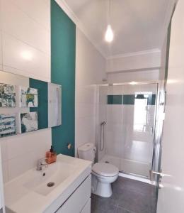 a white bathroom with a toilet and a shower at MAJU Concept House - Beja Centro Histórico in Beja