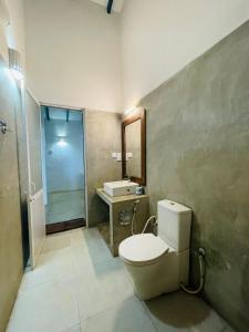 a bathroom with a toilet and a sink and a shower at RHO Sigiriya Lake Edge Retreat & Spa in Sigiriya