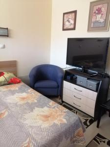 a bedroom with a bed and a flat screen tv at Cozopol Budjaka in Sozopol