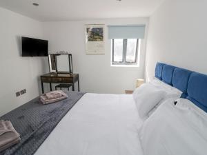 a bedroom with a white bed and a television at Plough Share in Gloucester