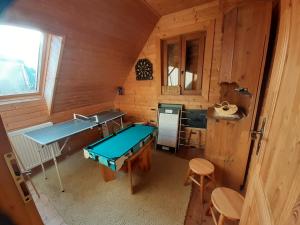 une petite chambre avec une table de ping-pong et une cuisine dans l'établissement Drevenica Deni, à Osturňa