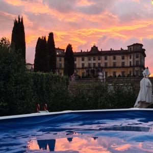 a pool in front of a building with a sunset at La Tana di Ulisse in Borgo a Buggiano