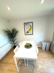 a white table with a bowl of fruit on it at Newly refurbished 2 bed- Didcot 