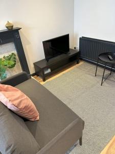 a living room with a couch and a flat screen tv at Newly refurbished 2 bed- Didcot 