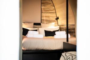 a bedroom with a large bed with white pillows at Glamping Maracujá - Oasis Paradise in Ribeira Brava