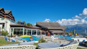 een resort met een zwembad en een gebouw bij Le Cormier - Appartement 6 personnes in Ovronnaz