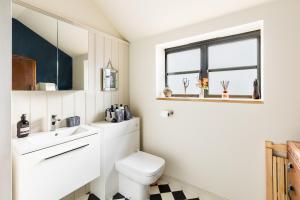a bathroom with a toilet and a sink and a window at Pittville Loft Apartment - Central Cheltenham Highly Rated with Free Parking in Gloucestershire