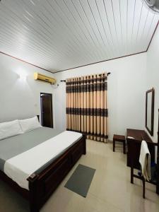 um quarto com uma cama e uma secretária e uma cama sidx sidx em Grand Okka Hotel em Buttala