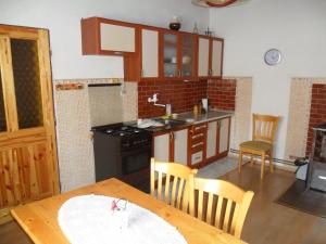 a kitchen with a table and a sink and a stove at Útulná chalupa za potokom Sklené in Sklené