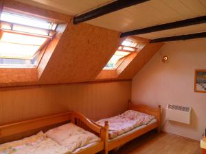 two beds in a room with two skylights at Útulná chalupa za potokom Sklené in Sklené