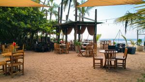 um grupo de mesas e cadeiras na praia em La Brisa Tranquila em Guachaca