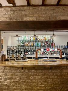 un bar con un montón de botellas de alcohol en White Hart Ufford- Stamford en Ufford