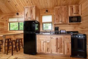 a kitchen with wooden cabinets and a black refrigerator at Wilderness Presidential Resort in Spotsylvania
