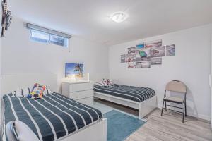 a bedroom with two beds and a chair at Executive Apartment - 2BDR Parking Self-check in - Walkout basement Lower Unit in Mississauga