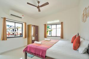 a bedroom with a large bed with a ceiling fan at Amazing Pool View Candolim Goa 1BHK Apartment in Candolim