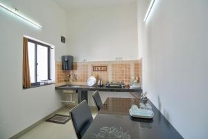 a kitchen with a table and chairs in a room at Amazing Pool View Candolim Goa 1BHK Apartment in Candolim