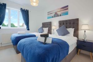 2 camas en un dormitorio con azul y blanco en Wonderful 2 bed accommodates 6 en Shenley Brook End
