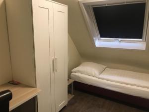 a small room with a bed and a window at Appartment Hotel Garni Elisabeth in Göppingen