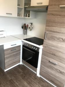 a small kitchen with a stove and a sink at Appartment Hotel Garni Elisabeth in Göppingen