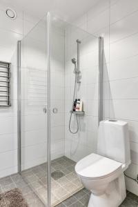 a white bathroom with a shower and a toilet at Cosy Urban Home in Stockholm in Stockholm