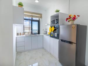 a kitchen with white cabinets and a stainless steel refrigerator at Sunset Vista in Flic-en-Flac