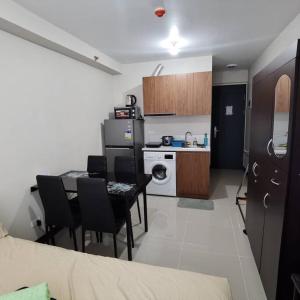 eine kleine Küche mit einem Tisch und Stühlen in einem Zimmer in der Unterkunft Affordable Condo w/ Wi-Fi, Pool & Shower Heater in Lapu Lapu City