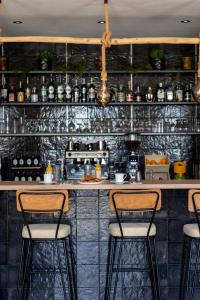 a bar with three bar stools in a kitchen at Hôtel Case Latine in Lama