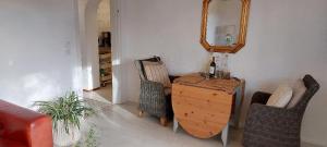Zimmer mit einem Tisch, Stühlen und einem Spiegel in der Unterkunft Landhof Osterdeich in Emmelsbüll-Horsbüll