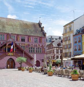 una calle de la ciudad con mesas, sillas y edificios en PURE#SPA#JACUZZI#Mulhouse, en Mulhouse