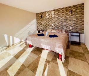 a bedroom with a bed and a stone wall at Cabañas el gigante in San Jose del Pacifico