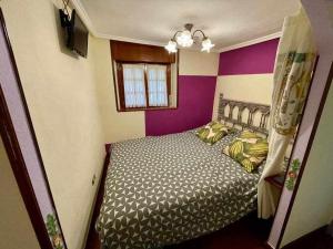 a bedroom with a bed and purple and white stripes at Utsa Eski -Piso con encanto en 1ª linea de puerto in Bermeo