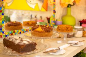 a table with different types of cakes on plates at Pousada das Galinhas in Porto De Galinhas