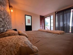a bedroom with two beds and a stone wall at Cabañas el gigante in San Jose del Pacifico