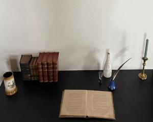 otwarta książka na stole z książkami i świecą w obiekcie Chalupa Milešín 