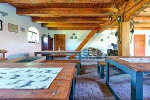 una sala de estar con mesas de madera y techos de madera. en Chalupa Milešín 