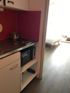 a kitchen with a stove and a microwave at Studio 233, Port Camargue, Parking, WiFi, Piscine, 2 personnes in Le Grau-du-Roi