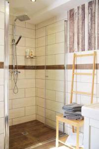 a bathroom with a shower and a wooden chair at Maison Harzliesel in Harzgerode