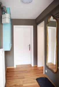 a room with a mirror and a wooden floor at Maison Harzliesel in Harzgerode