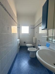 een badkamer met 2 toiletten, een wastafel en een bad bij Laguna Grande - Appartamenti in Bibione