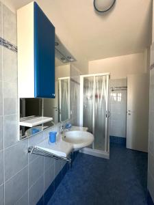 een badkamer met een witte wastafel en een douche bij Laguna Grande - Appartamenti in Bibione