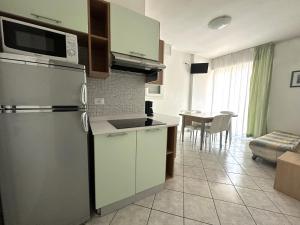 een keuken met een koelkast en een eetkamer bij Laguna Grande - Appartamenti in Bibione +11 foto's