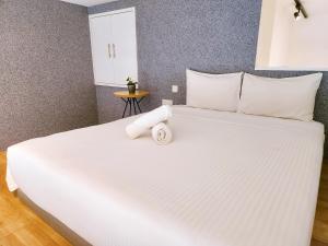 a large white bed with a towel on it at The Establishment Bangsar in Kuala Lumpur +24 photos
